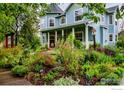 Captivating view of the house's exterior, complemented by a lush, colorful garden and inviting front porch at 1369 Padfield Pl, Erie, CO 80516