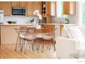 Bright kitchen with an eat-in dining table, stainless steel appliances, and hardwood floors at 1414 Hoffman Dr, Erie, CO 80516