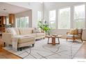 Bright, open living room with large windows, hardwood floors and modern furnishings at 1414 Hoffman Dr, Erie, CO 80516