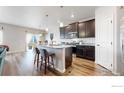 Kitchen island with barstool seating overlooks the breakfast nook and Gathering room at 14868 Guernsey Dr, Mead, CO 80542
