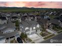 An aerial view of the home in a neighborhood near farmland with mountain views in the distance at 1840 Marquette Dr, Erie, CO 80516