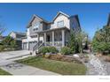 Charming home showcasing a covered porch, well-manicured landscaping, and a two-car garage at 1840 Marquette Dr, Erie, CO 80516