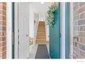 Welcoming entryway features a stylish teal door, wood stairs, and bright, neutral decor at 1866 Mallard Dr, Superior, CO 80027