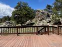 Large wooden deck overlooking beautiful rock outcropping and trees perfect for outdoor living at 258 Post Boy Rd, Boulder, CO 80302