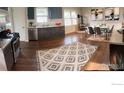 Open kitchen with stainless appliances, wood floors, a dining area, and a decorative rug, creating a welcoming space at 258 Post Boy Rd, Boulder, CO 80302