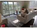 Bright living room with a sliding glass door leading to a balcony with great outdoor views and comfortable seating at 258 Post Boy Rd, Boulder, CO 80302