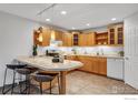 Bright kitchen featuring wood cabinets, tile countertops, and a breakfast bar with seating at 3300 Bridger Trl # 111, Boulder, CO 80301