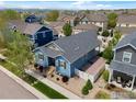 This charming blue home includes a well-manicured lawn and landscaped garden beds at 569 Jackson St, Lafayette, CO 80026