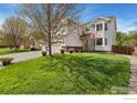 A well maintained two story home with a three-car garage and a lush green lawn at 5910 Blue Mountain Cir, Longmont, CO 80503