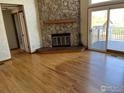 Spacious living room featuring a stone fireplace and sliding glass doors to an outdoor deck at 5958 S Swadley Way, Littleton, CO 80127