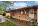 Attractive brick home with a covered porch, double garage, and well-kept landscaping at 6432 Owens St, Arvada, CO 80004