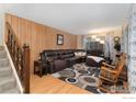 Spacious living room with wood paneling, plush seating, and cozy rocking chair at 6432 Owens St, Arvada, CO 80004