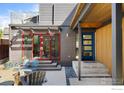 Modern home exterior with a blue front door, red framed windows, and outdoor seating area at 711 Hawthorn Ave, Boulder, CO 80304