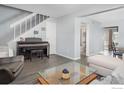 Bright open-concept living room with a piano, staircase, and glass coffee table at 750 W Moorhead Cir # A, Boulder, CO 80305
