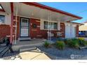 Cozy brick home with a welcoming front porch seating area at 8089 Greenwood Blvd, Denver, CO 80221