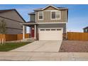 A two-story house features a two-car garage, a vibrant red door, and a well-kept green lawn at 816 Leeward St, Lochbuie, CO 80603