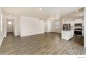 Bright, open-concept living space with wood floors, white walls, and ample natural light at 816 Leeward St, Lochbuie, CO 80603