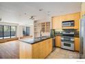 Modern kitchen featuring an island, stainless steel appliances and light wood cabinetry, creating a warm and inviting space at 836 Walnut St # B, Boulder, CO 80302
