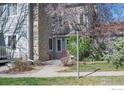 Charming townhouse exterior with stone accents and a beautifully landscaped front yard at 8479 Everett Way # E, Arvada, CO 80005