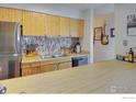 Well-equipped kitchen with stainless steel appliances, light wood cabinets, and a breakfast bar at 8479 Everett Way # E, Arvada, CO 80005