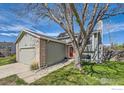 Charming home with neutral siding and brick accents, features a red front door under a mature shade tree at 9125 W 95Th Ave, Westminster, CO 80021