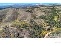 Aerial view of the property showcasing the mountainous terrain and surrounding foliage at 98 Rim Rd, Boulder, CO 80302
