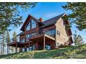 View of the home exterior from the ground, featuring a walk-out basement and multiple decks at 98 Rim Rd, Boulder, CO 80302