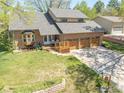 Aerial view of a home highlighting the landscaping, deck and three-car garage at 128 Baylor Dr, Longmont, CO 80503