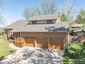Overhead angle of an inviting home featuring a three-car garage and a deck at 128 Baylor Dr, Longmont, CO 80503