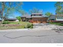 Attractive brick home showcasing a well-manicured lawn and ample driveway space at 128 Baylor Dr, Longmont, CO 80503