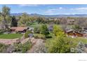 Wide aerial view showcasing the home's setting with mature trees, a garden, and mountain views at 1322 Wicklow St, Boulder, CO 80303