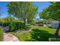 Lush backyard featuring mature trees, a well-kept lawn, landscaping, and a storage shed at 1322 Wicklow St, Boulder, CO 80303