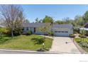 Single-story home featuring an attached two-car garage and a driveway with a basketball hoop at 1322 Wicklow St, Boulder, CO 80303