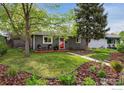Inviting gray single-story home with manicured lawn and mature trees at 1343 Gay St, Longmont, CO 80501
