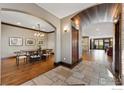 Spacious foyer with stone tile flooring, archways, hardwood floors, and dining area beyond at 1376 S Clayton St, Denver, CO 80210