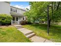 Exterior view featuring a well-manicured lawn and charming entrance, complemented by a lush green tree at 1419 Red Mountain Dr # 45, Longmont, CO 80504