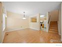 Open-concept living area with wood floors, seamlessly flowing into the adjacent kitchen and staircase at 1419 Red Mountain Dr # 45, Longmont, CO 80504
