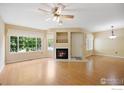 Bright living room boasting a fireplace, large windows with natural light, and laminate flooring at 1419 Red Mountain Dr # 45, Longmont, CO 80504