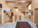 Grand foyer with soaring ceilings, decorative beams, marble floors and artistic wall decor at 1426 Rembrandt Rd, Boulder, CO 80302
