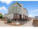 Contemporary townhouse showcasing green and gray siding, brick accents, and accessible ramp at 14283 Currant St, Broomfield, CO 80020