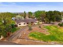 An aerial view of a ranch style home on a large lot with mature trees and circular driveway at 14531 Country Hills Dr, Brighton, CO 80601