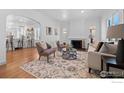 Bright living room featuring hardwood floors, a cozy fireplace, and comfortable seating arrangements at 1467 Clermont St, Denver, CO 80220