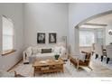 Bright living room boasts high ceilings, lots of natural light, modern decor and a cozy seating area at 15453 E 109Th Ave, Commerce City, CO 80022