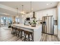 Bright, modern kitchen with a large island, pendant lighting, and stainless steel appliances at 16637 Promenade St, Broomfield, CO 80023