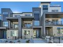 Contemporary townhouse showcasing a modern facade, private balconies, and well-maintained landscaping at 1718 Peak Loop, Broomfield, CO 80023