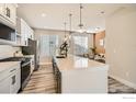 Contemporary kitchen featuring a large island, stainless steel appliances, and eat-in dining area at 1718 Peak Loop, Broomfield, CO 80023