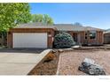 Beautiful brick home featuring landscaped yard, two-car garage, and mature landscaping at 2072 Skylark Ct, Longmont, CO 80503