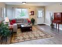 Bright living room featuring a comfortable gray sectional, hardwood floors, and stylish decor at 2793 Red Wheat Trl, Berthoud, CO 80513