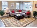 Inviting living room featuring a comfortable gray sectional sofa, ottoman, and large floral rug at 2793 Red Wheat Trl, Berthoud, CO 80513