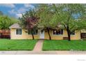 Inviting single-story home with a lush green lawn, mature trees, and a quaint walkway leading to the front door at 3090 17Th St, Boulder, CO 80304